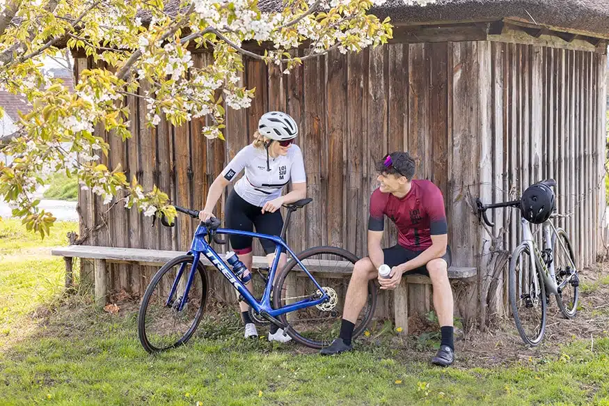 zwei Radfahrer machen Pause unter einem blühenden Kirschbaum
